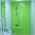 bathroom has a fully accessible wet room facility with nonslip flooring, low level seating under an adjustable shower wi
